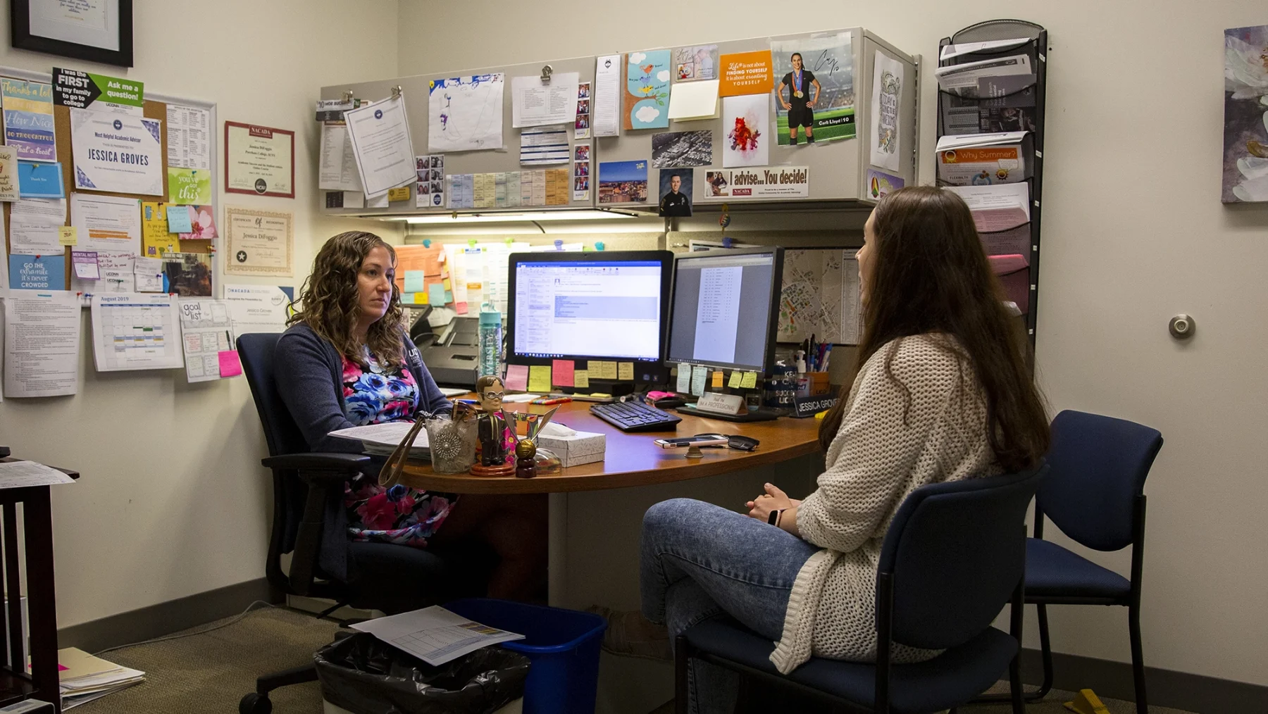 UConn Advisor sitting at desk having a discussion.
